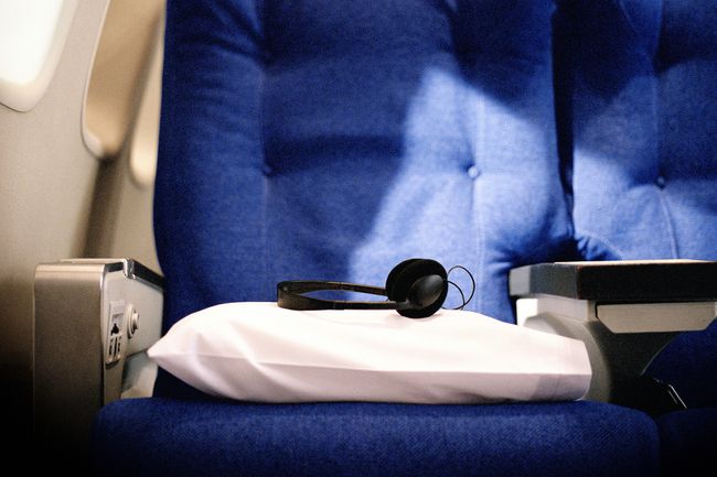 Подушка и наушники на сиденье в авиалиниях
