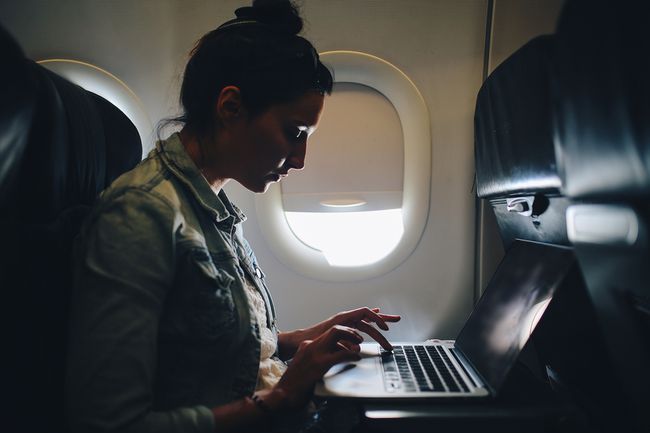 Молодая женщина заканчивает работу в самолете