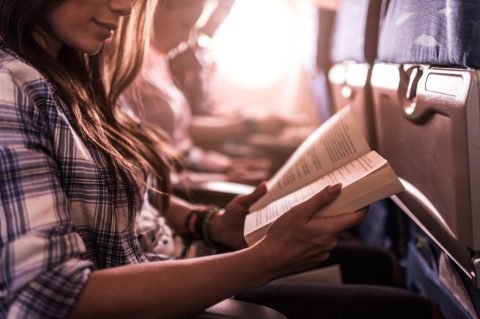 женщина читает в самолете