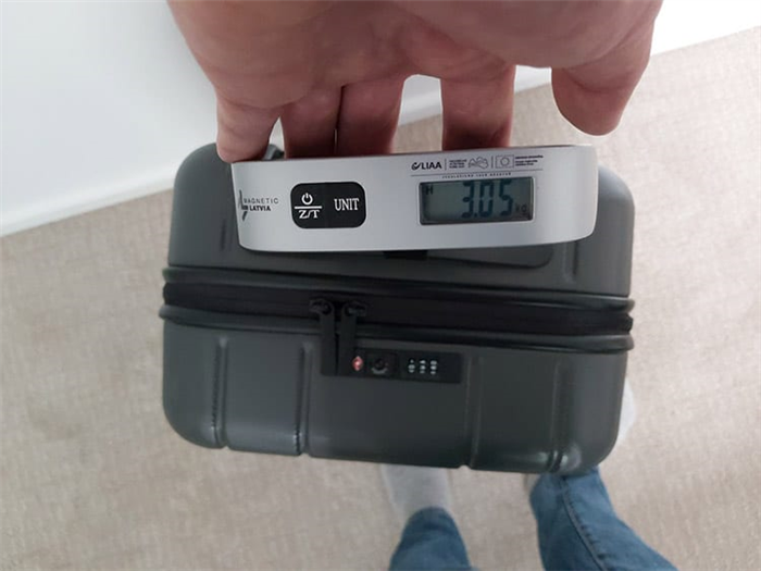 Проверка веса багажа Честера с помощью багажных весов