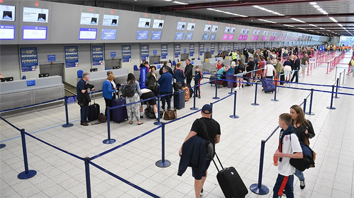 Люди стоят в очереди на регистрацию в аэропорту