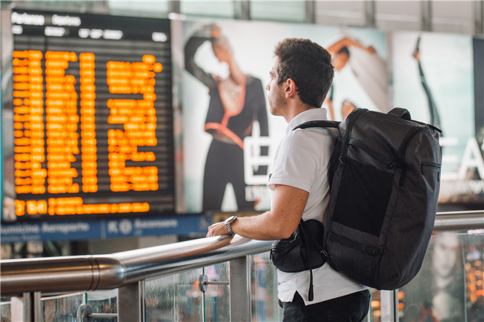 Мужчина проверяет табло вылета в аэропорту