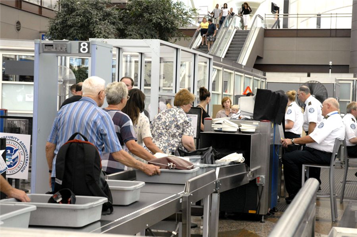 Люди в очереди в службе безопасности аэропорта