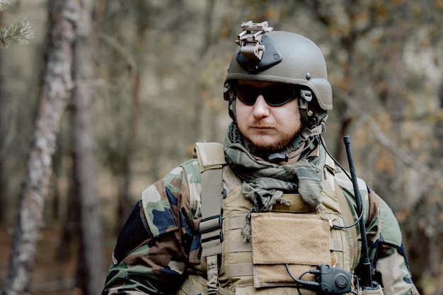 Портрет бородатого солдата средних лет в военной форме и каске с наушниками