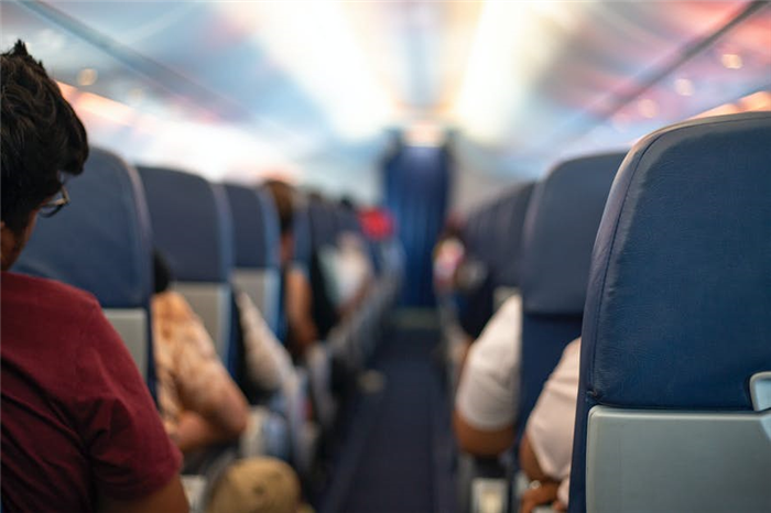 Снимок пустого прохода самолета, когда все пассажиры находятся на своих местах 