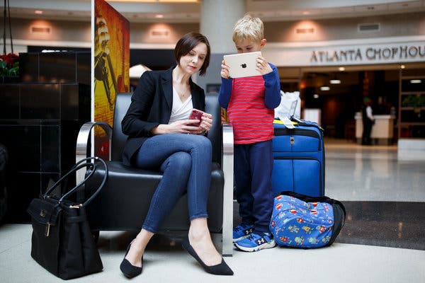 Линдси Ренфро и ее сын Уилл Маккинни, 6 лет, в аэропорту Атланты после прибытия рейсом из Миннесоты. Она сказала, что не будет скучать по экранам на спинках кресел. “В жизни везде есть экраны”